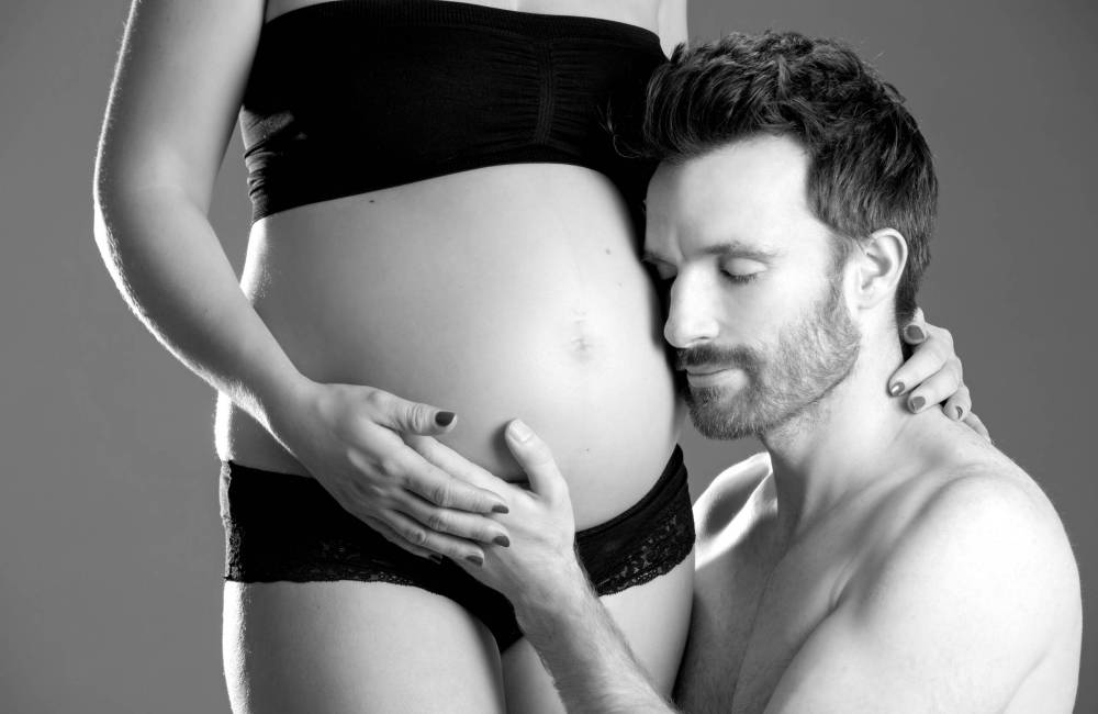 Schwarzweiß-Babybauchfoto eines Paares